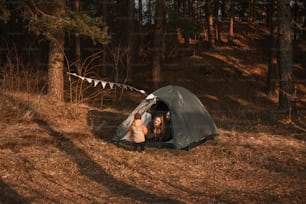 a couple of people sitting inside of a tent