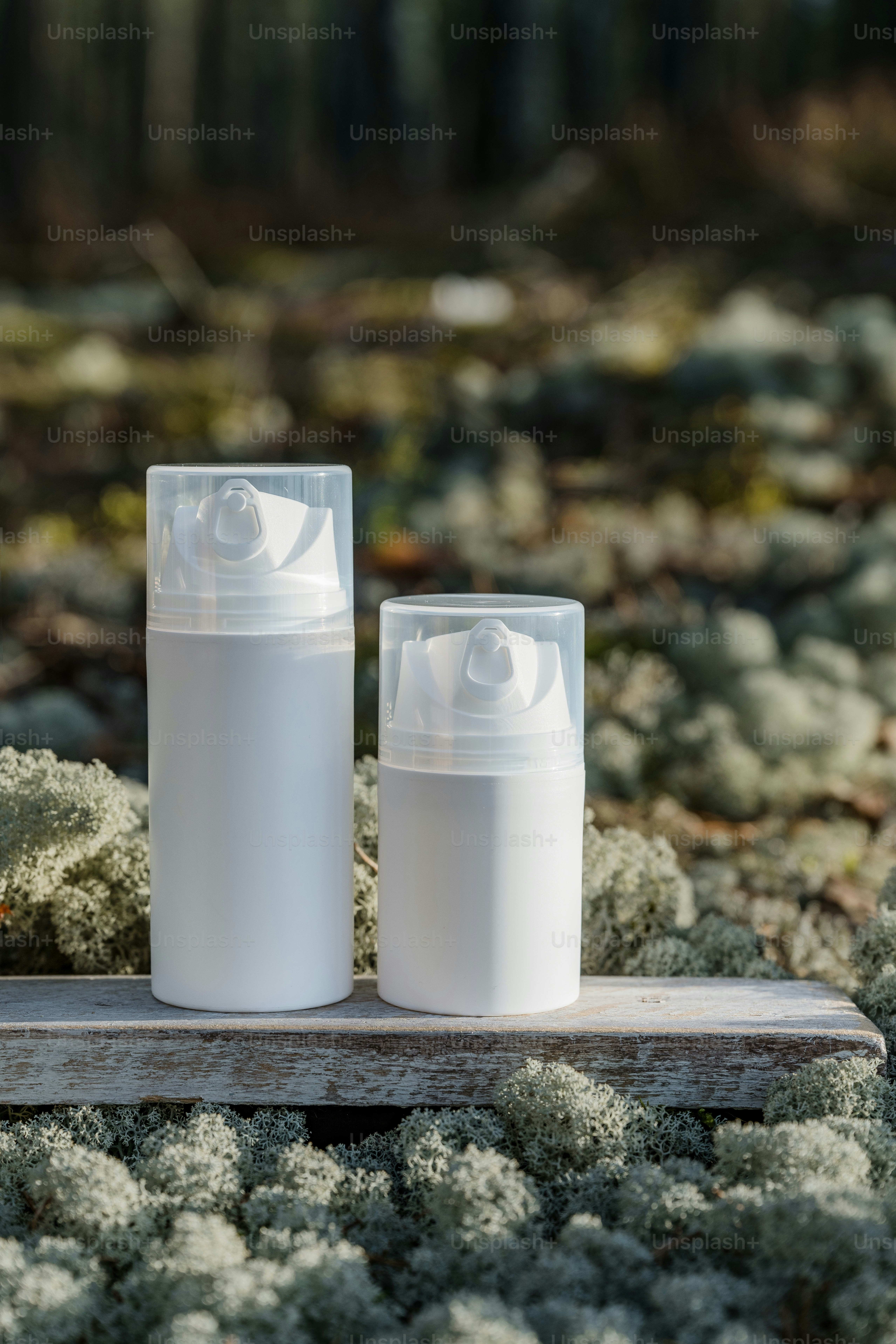 two bottles sitting on top of a piece of wood