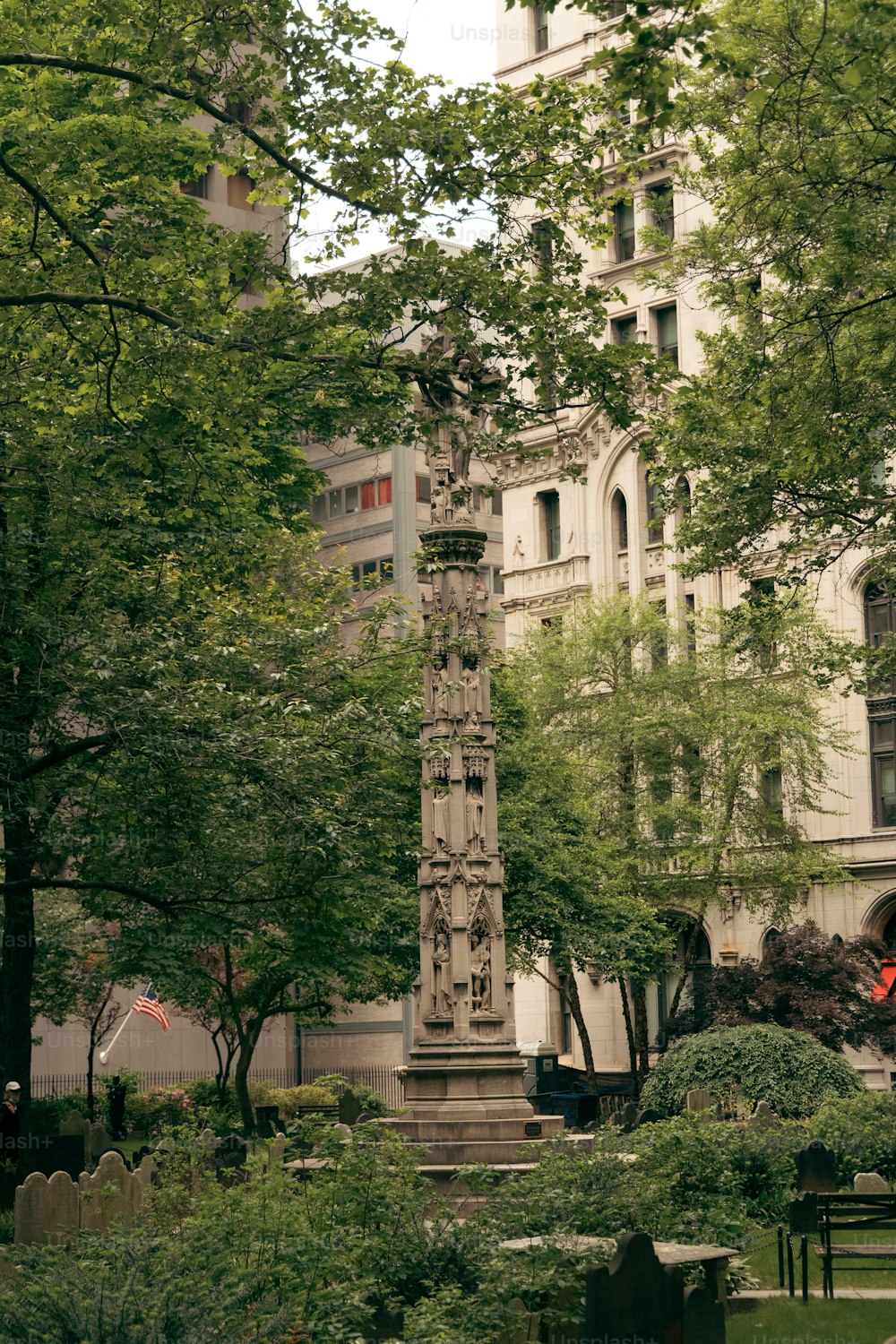 uma torre do relógio alta sentada no meio de um parque