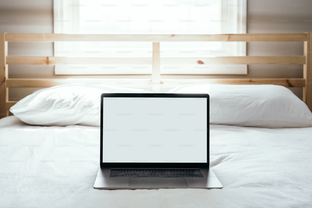 Ein Laptop, der auf einem Bett sitzt