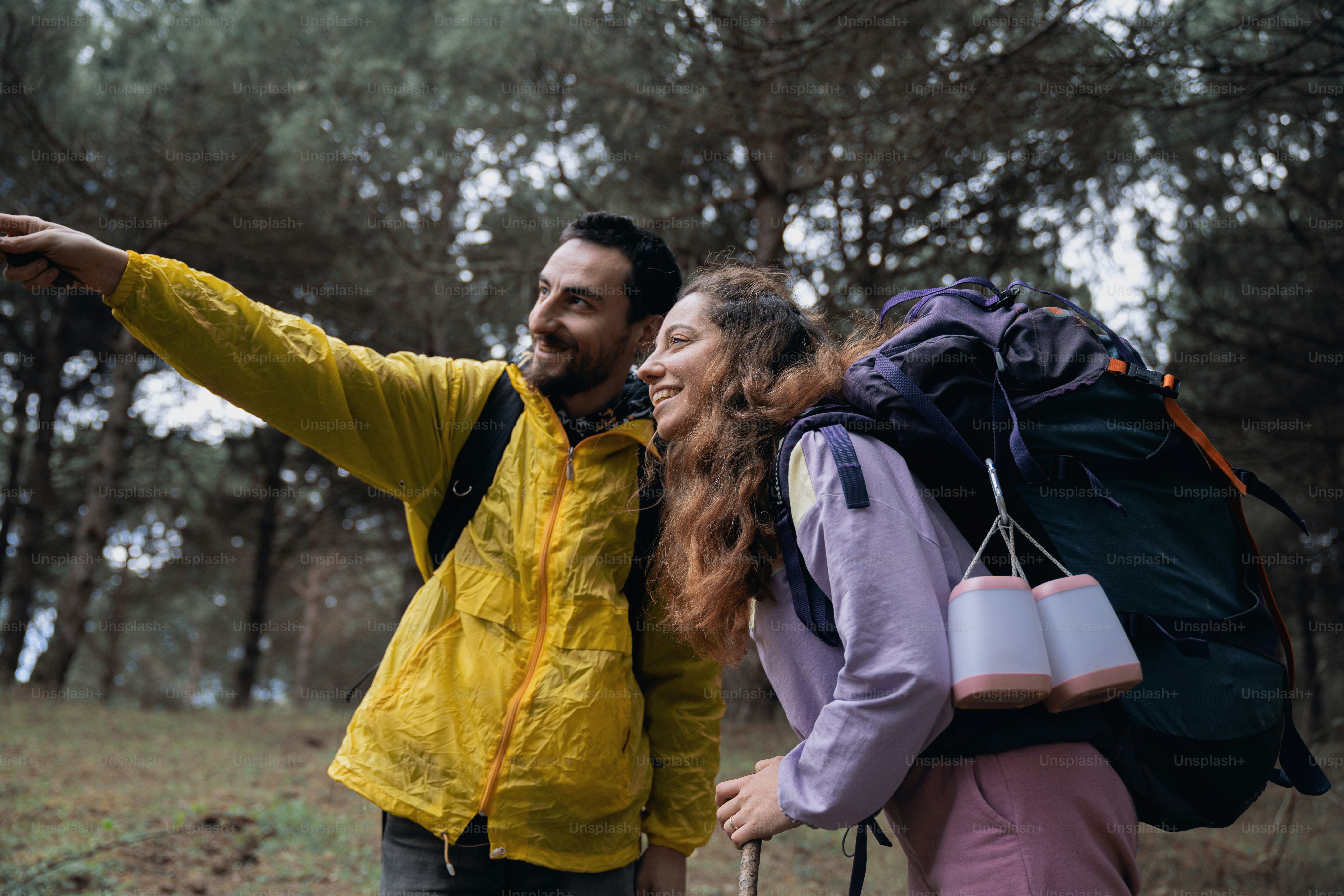 a man and a woman are walking through the woods