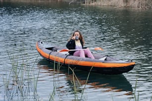 a girl is sitting in a boat on the water