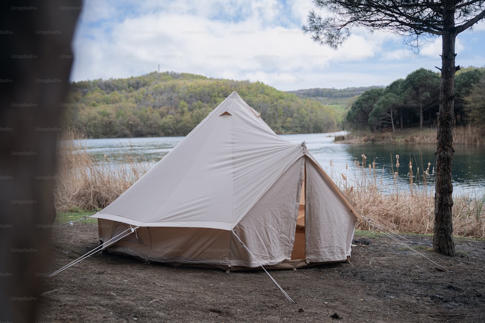 a tent set up next to a body of water
