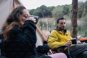 텐트 옆에 앉아 있는 남자와 여자