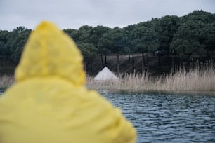 a person in a yellow jacket looking out over a body of water