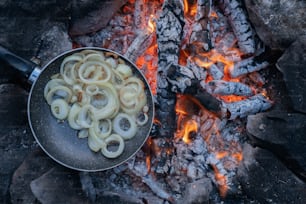 a frying pan filled with food sitting on top of a fire