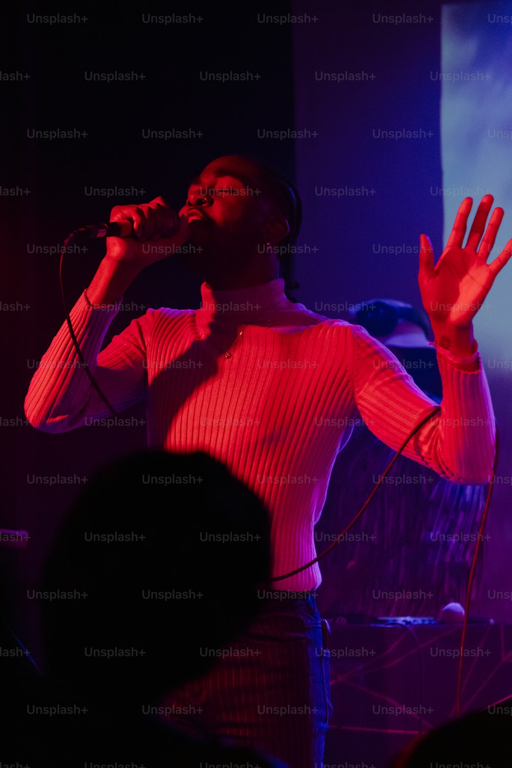 a woman singing into a microphone in front of a crowd