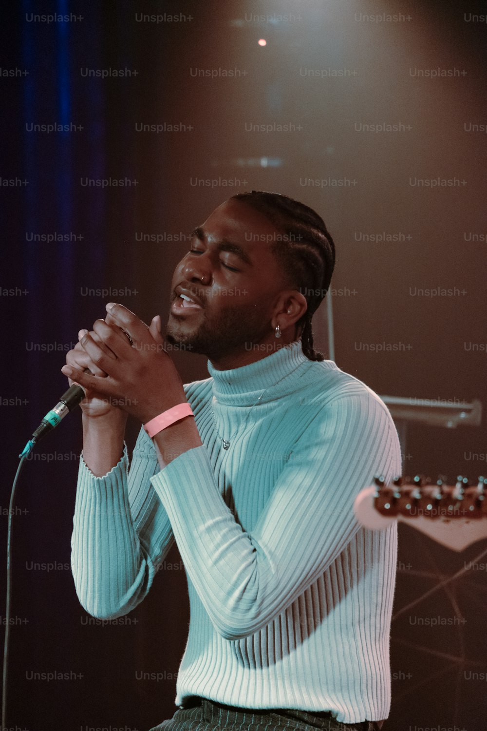 a man holding a microphone while standing in front of a microphone