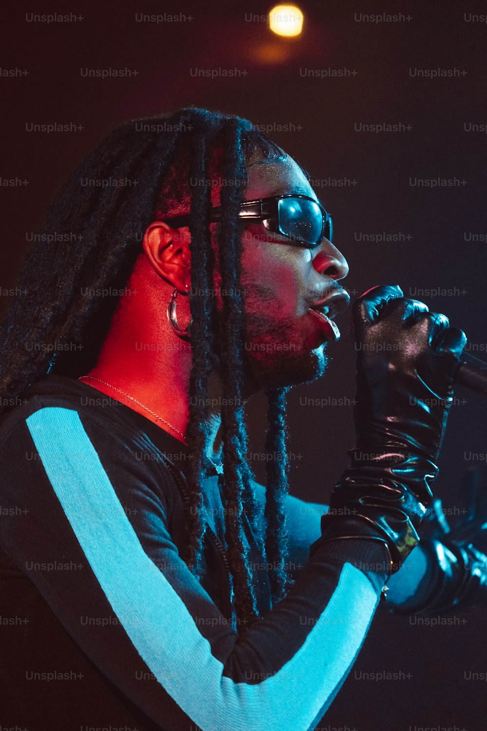 a man with long dreadlocks holding a microphone