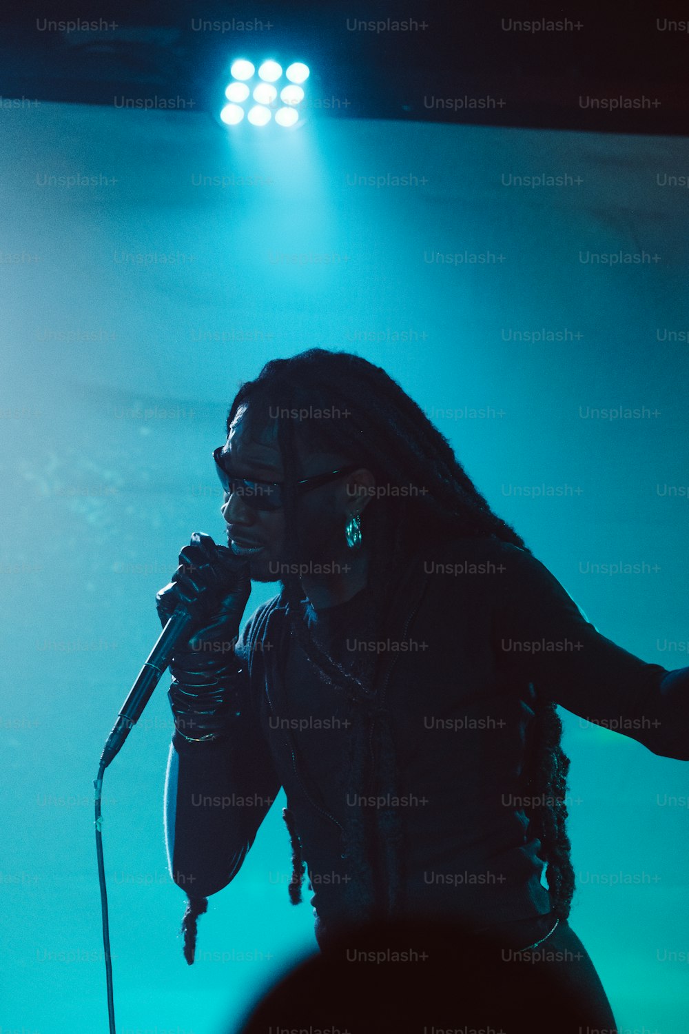 uma mulher cantando em um microfone no palco