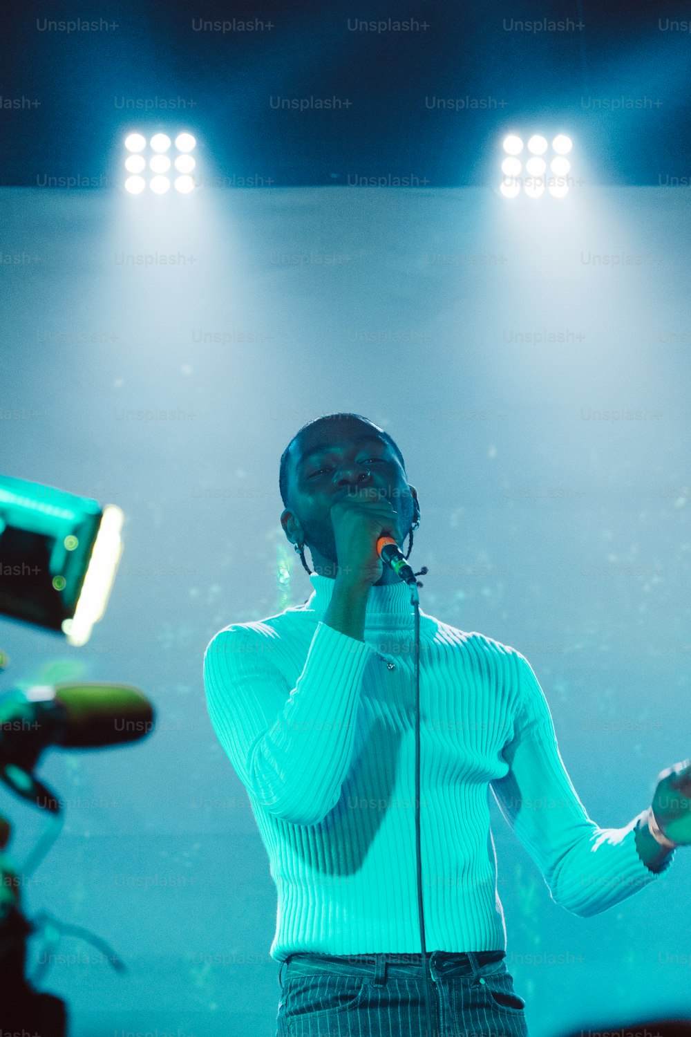 a woman singing into a microphone on stage