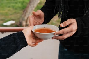 a couple of people that are holding a bowl of food