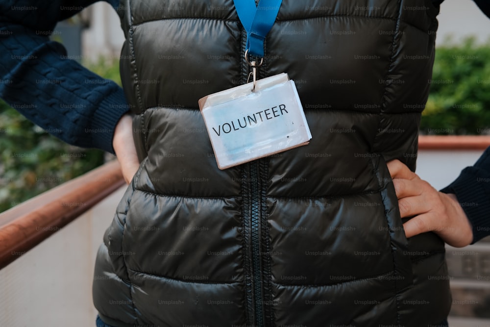 a woman wearing a vest with a volunteer badge on it