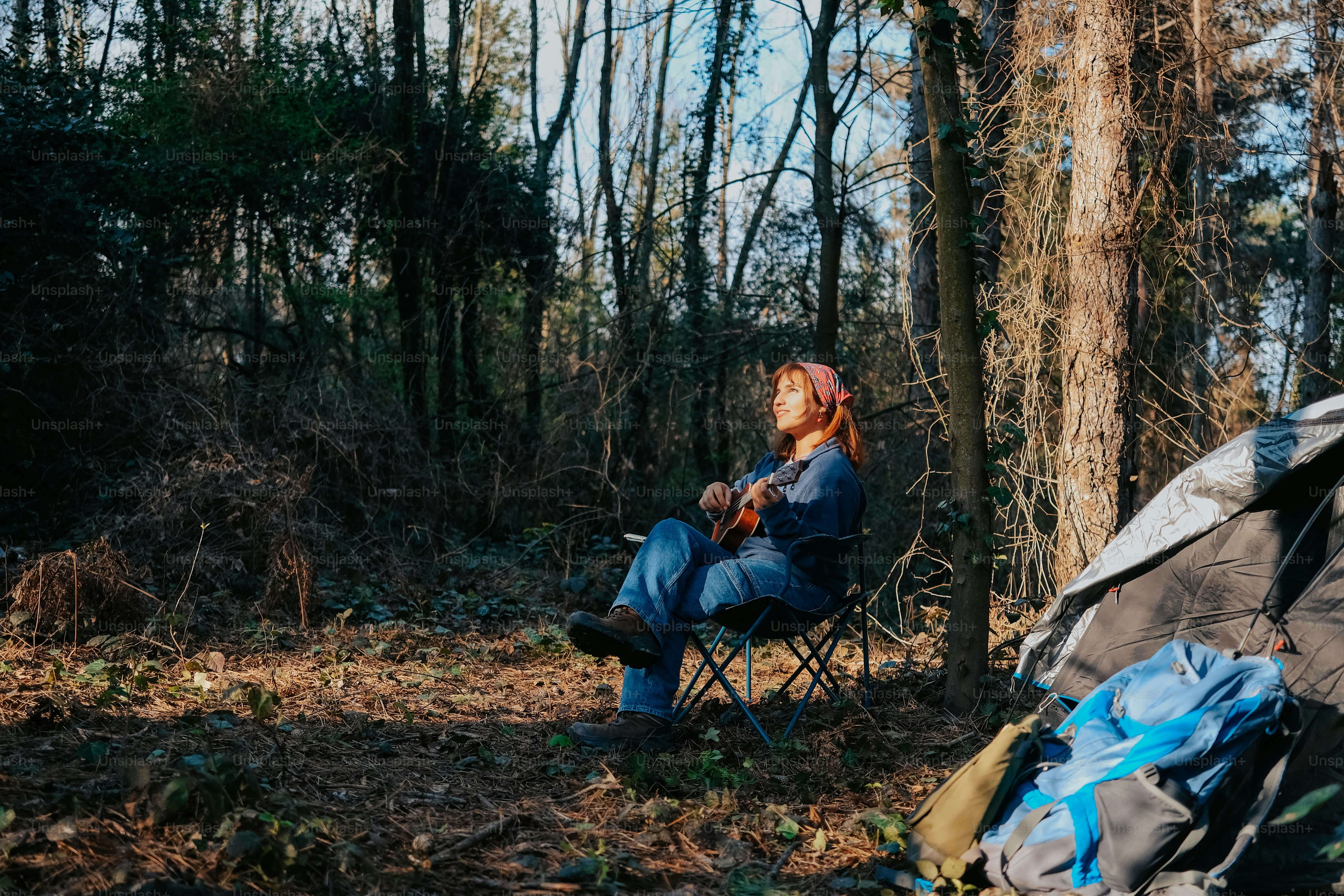 a woman sitting in a chair in the woods