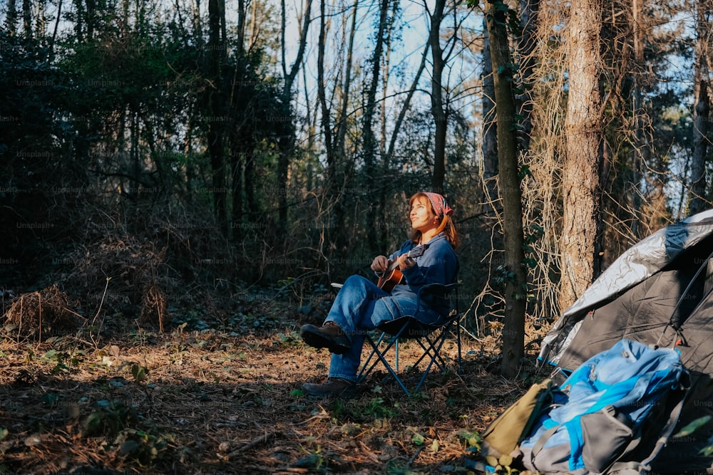 Una mujer sentada en una silla en el bosque