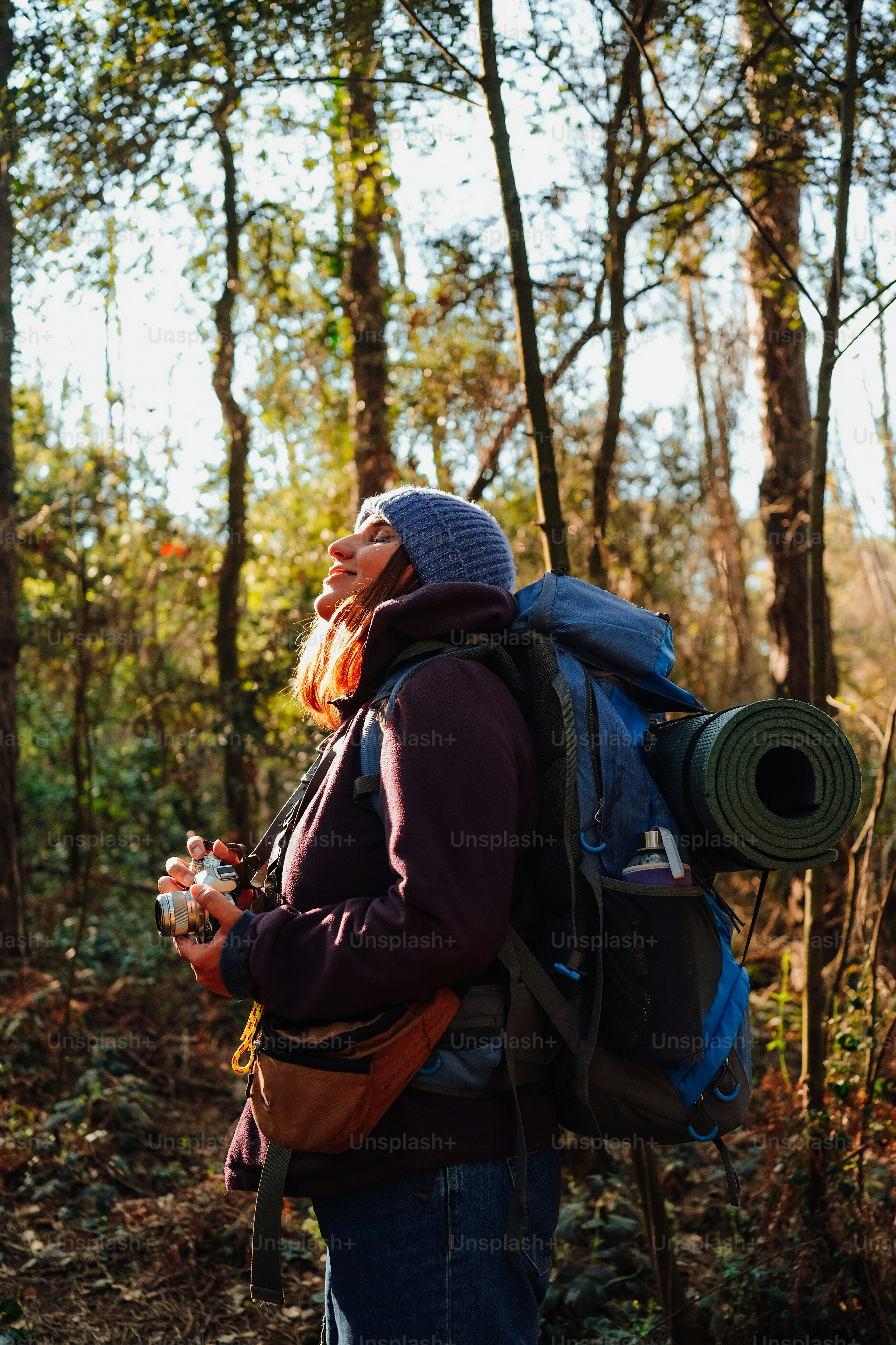 a man with a backpack is standing in the woods