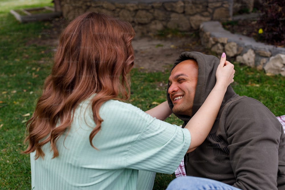 a woman sitting on the ground next to a man