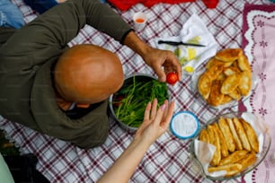 a man and a woman sitting at a table with food