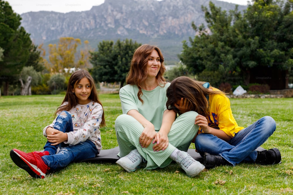 a woman sitting on the ground with two children