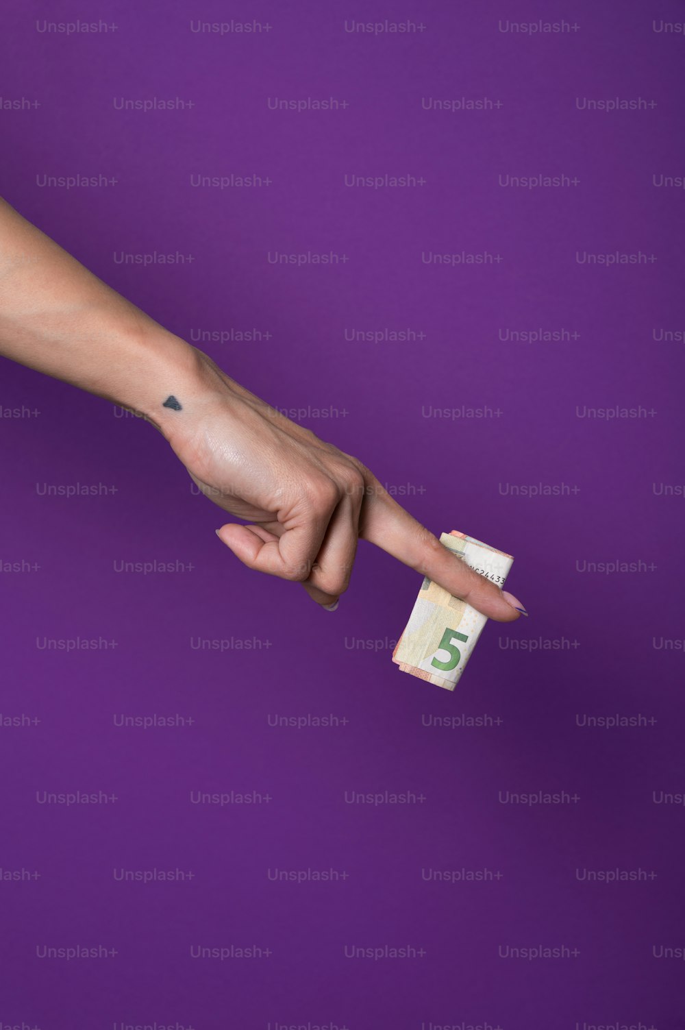 Die Hand einer Frau zeigt auf einen Fünf-Dollar-Schein