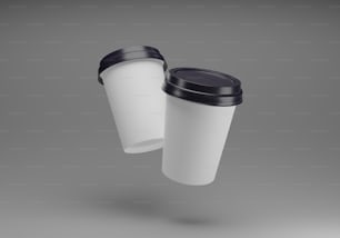 two white coffee cups with black lids are flying through the air
