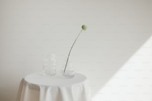 a white table topped with a vase filled with a flower