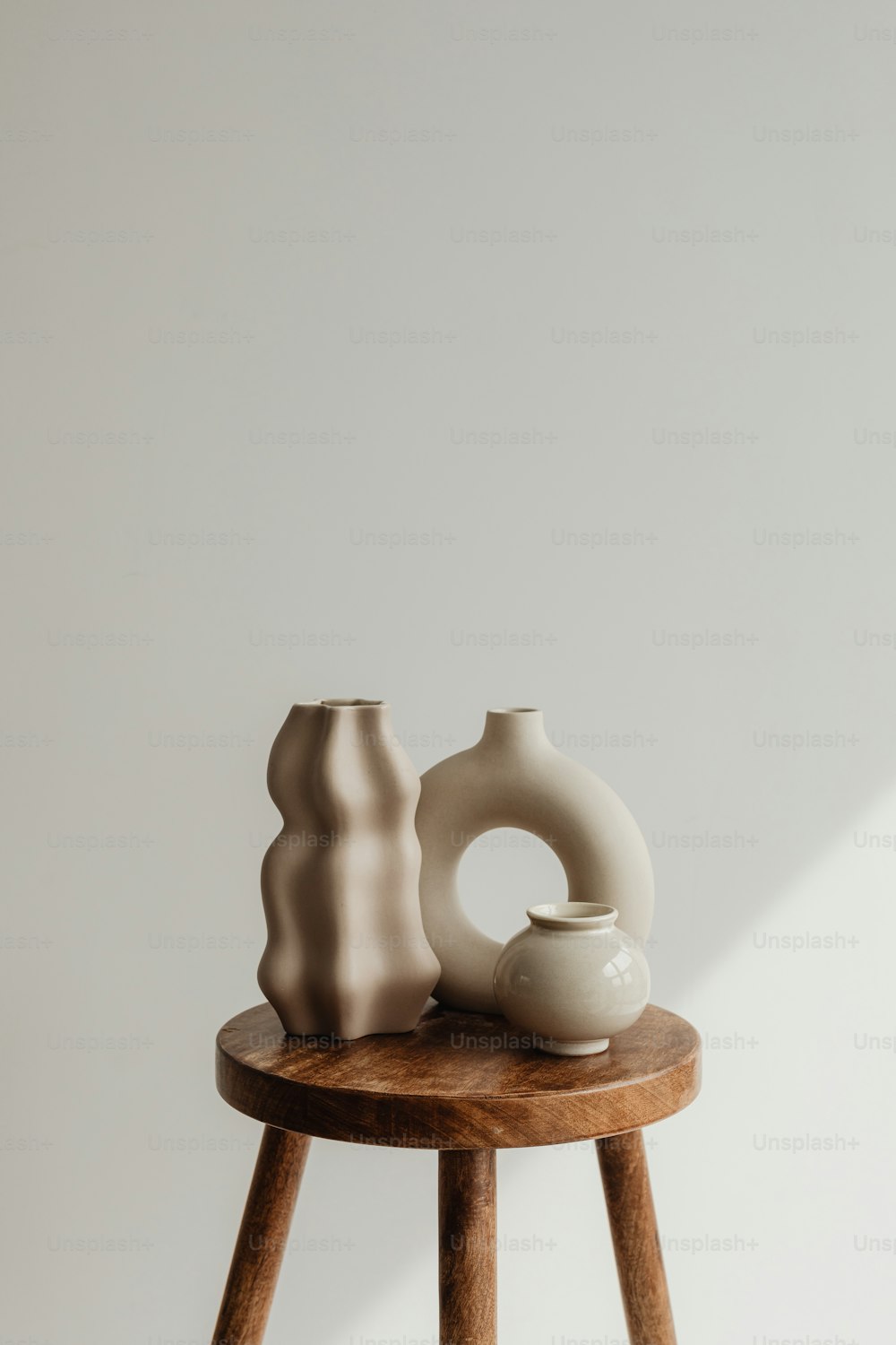 two vases sitting on a small wooden table