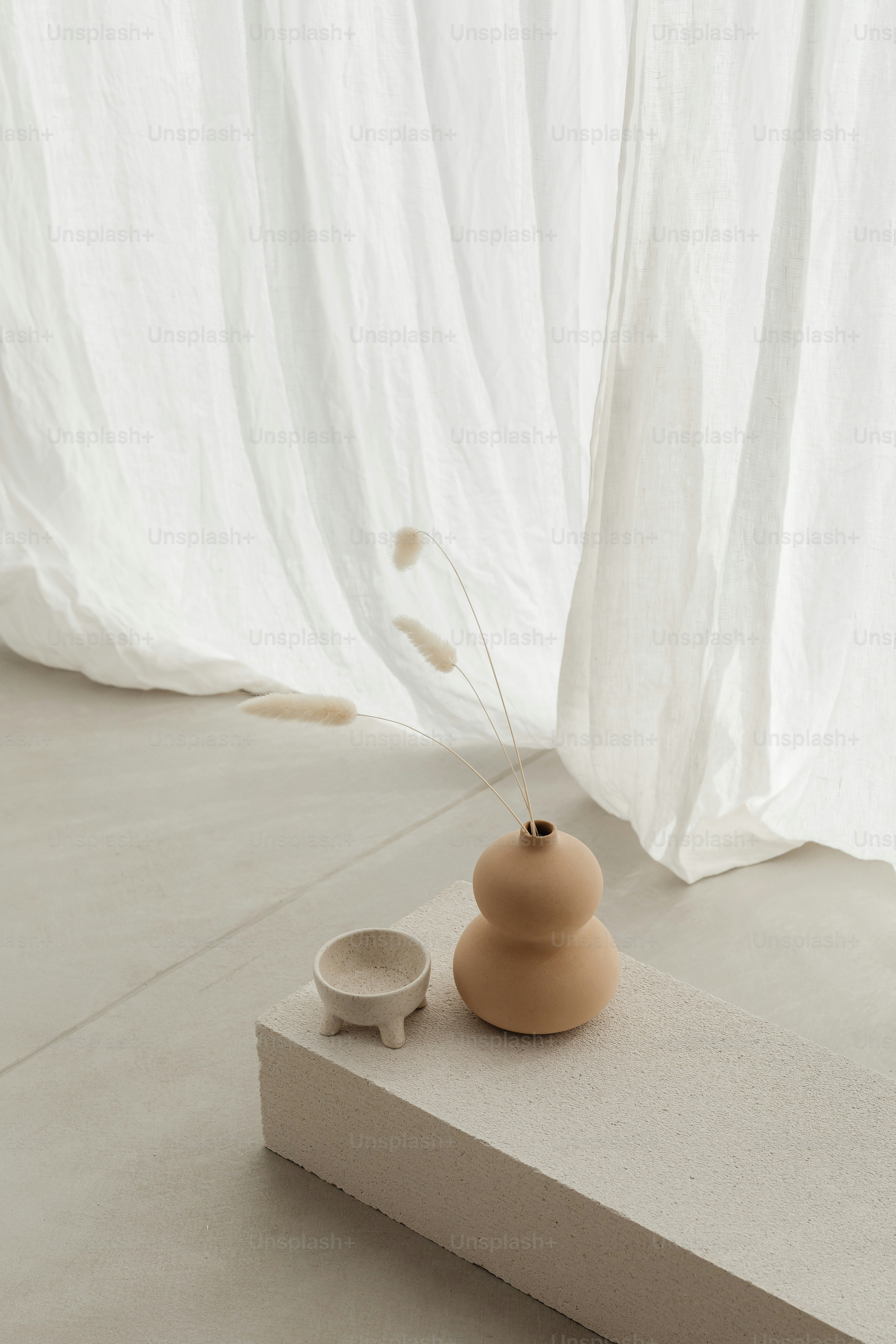 a small vase sitting on top of a block of concrete