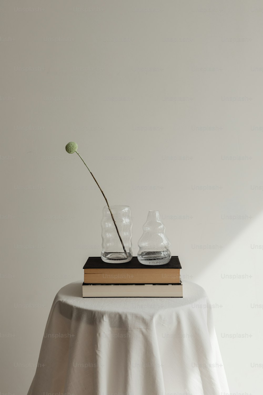 a vase with a flower sitting on top of a book