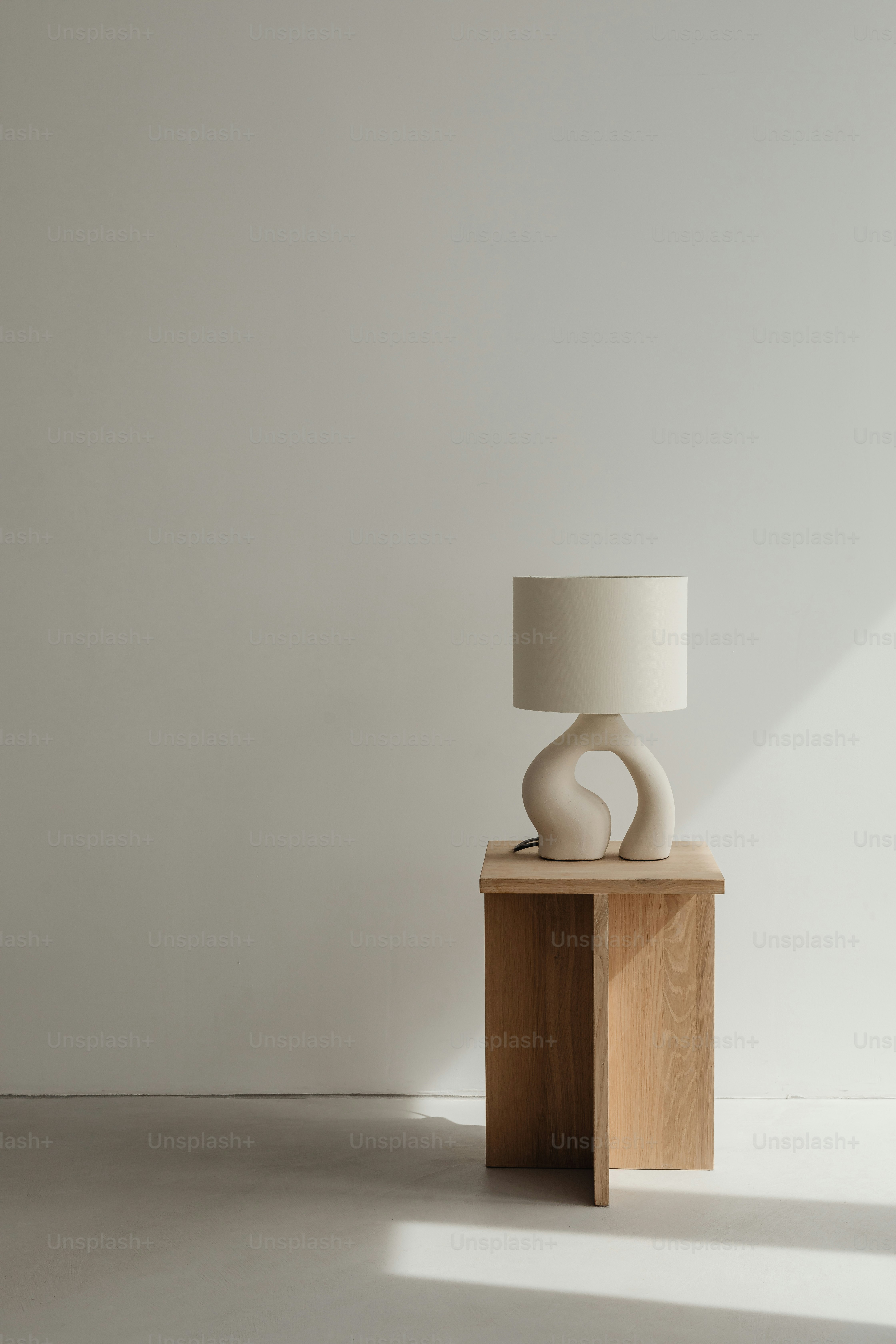 eine weiße Lampe, die auf einem Holztisch sitzt