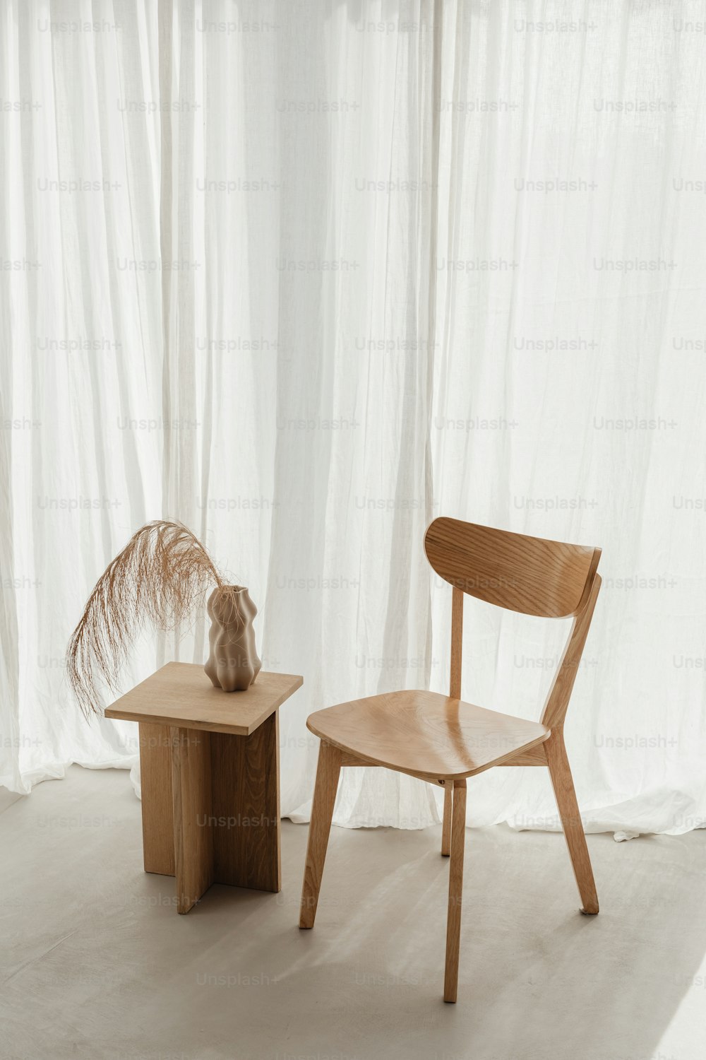 uma cadeira de madeira ao lado de uma pequena mesa de madeira