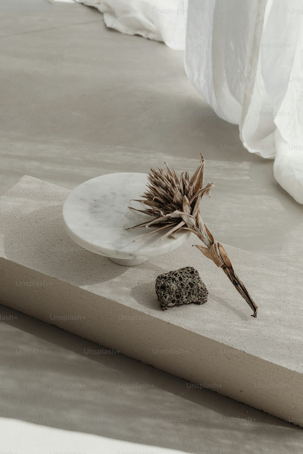 um prato branco sentado em cima de uma mesa ao lado de uma rocha