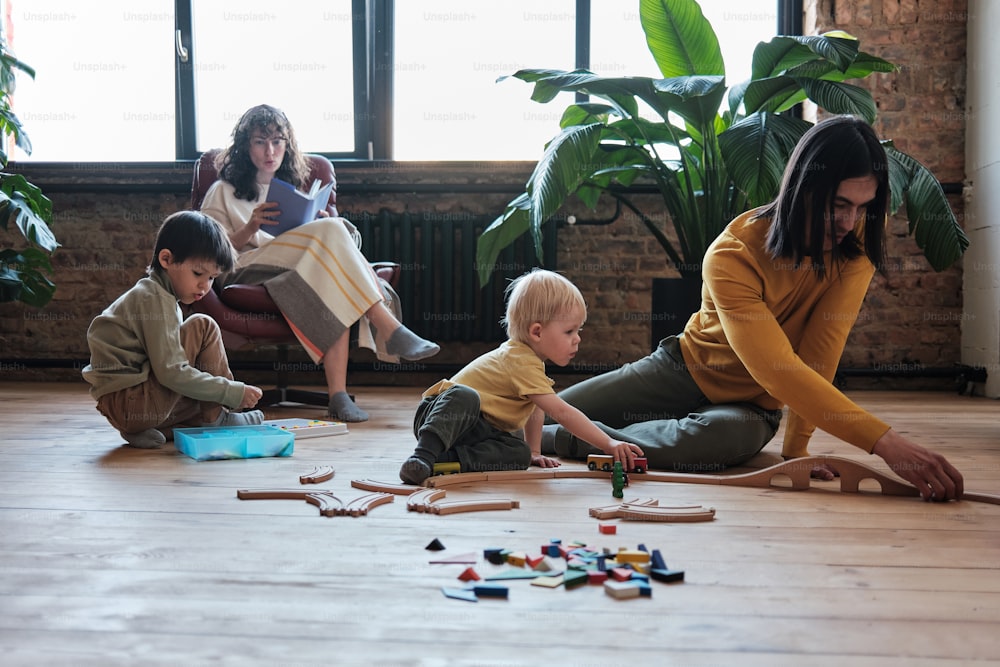 a woman playing with children on the floor