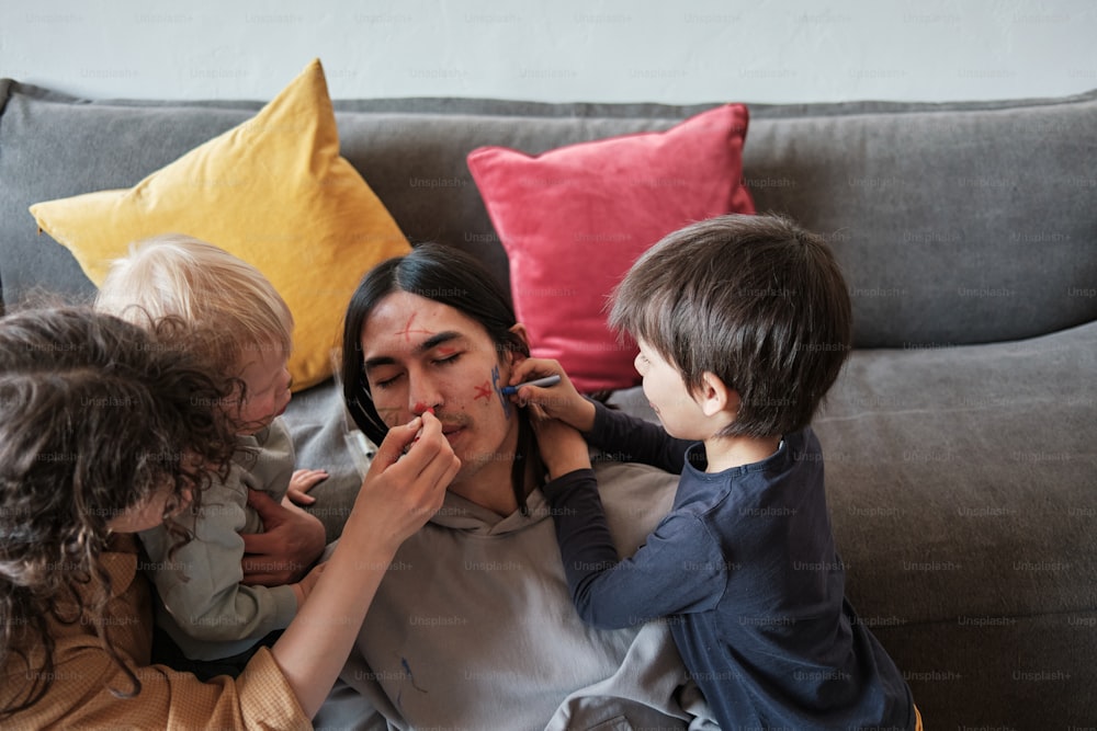 a woman sitting on a couch with four children