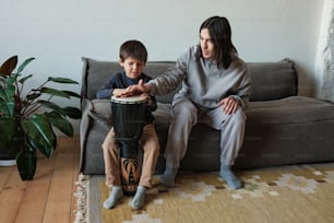 a woman sitting on a couch next to a boy