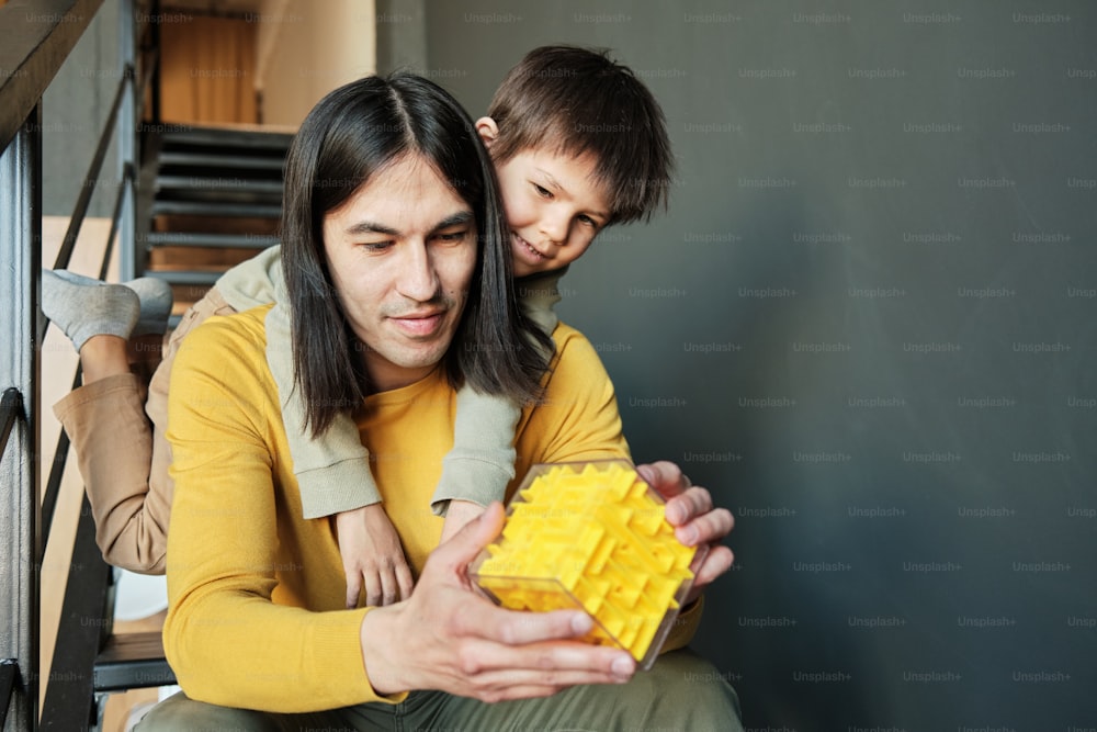 a man holding a child who is holding a yellow box