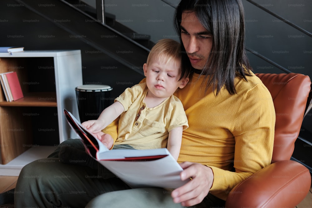 a man reading a book to a child