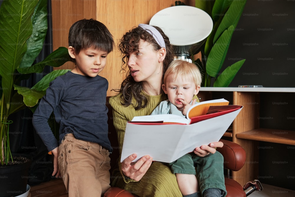a woman reading a book to two children