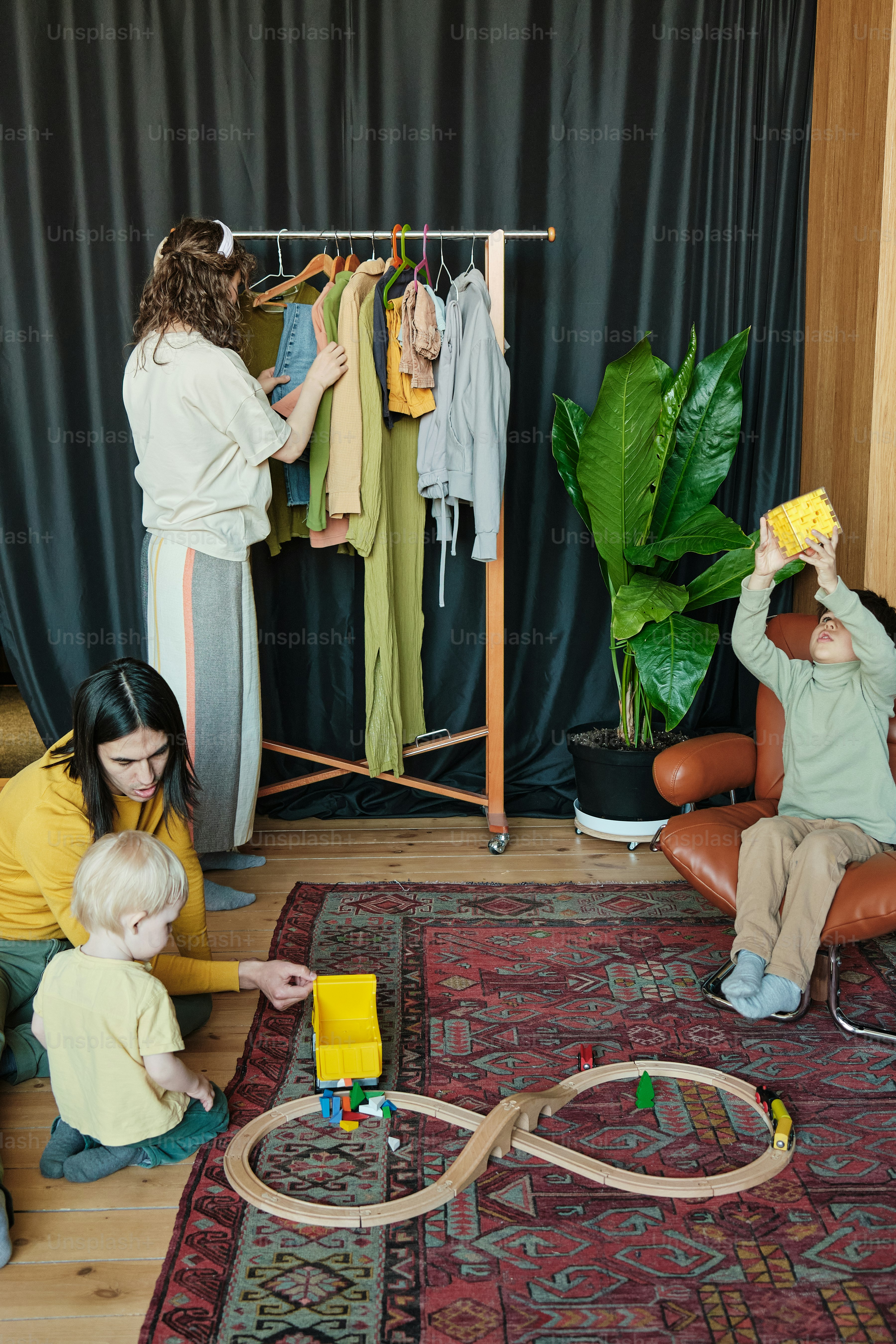 Una mujer y dos niños jugando con un tren