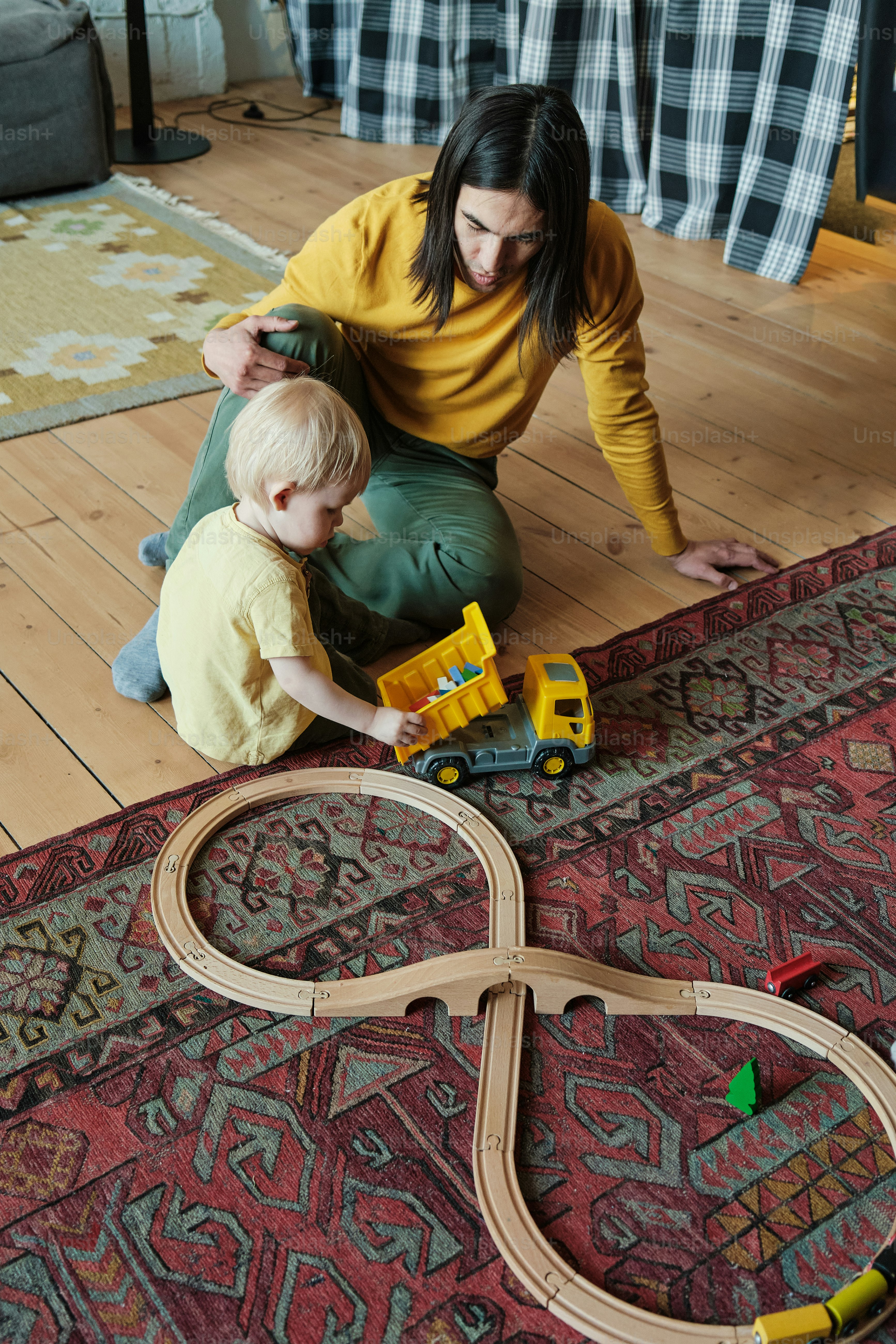 eine Frau, die mit einem Kind auf dem Boden spielt