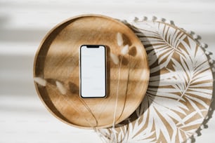 un telefono cellulare seduto sopra un piatto di legno