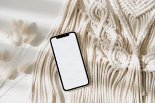 Un teléfono celular sentado encima de una manta blanca