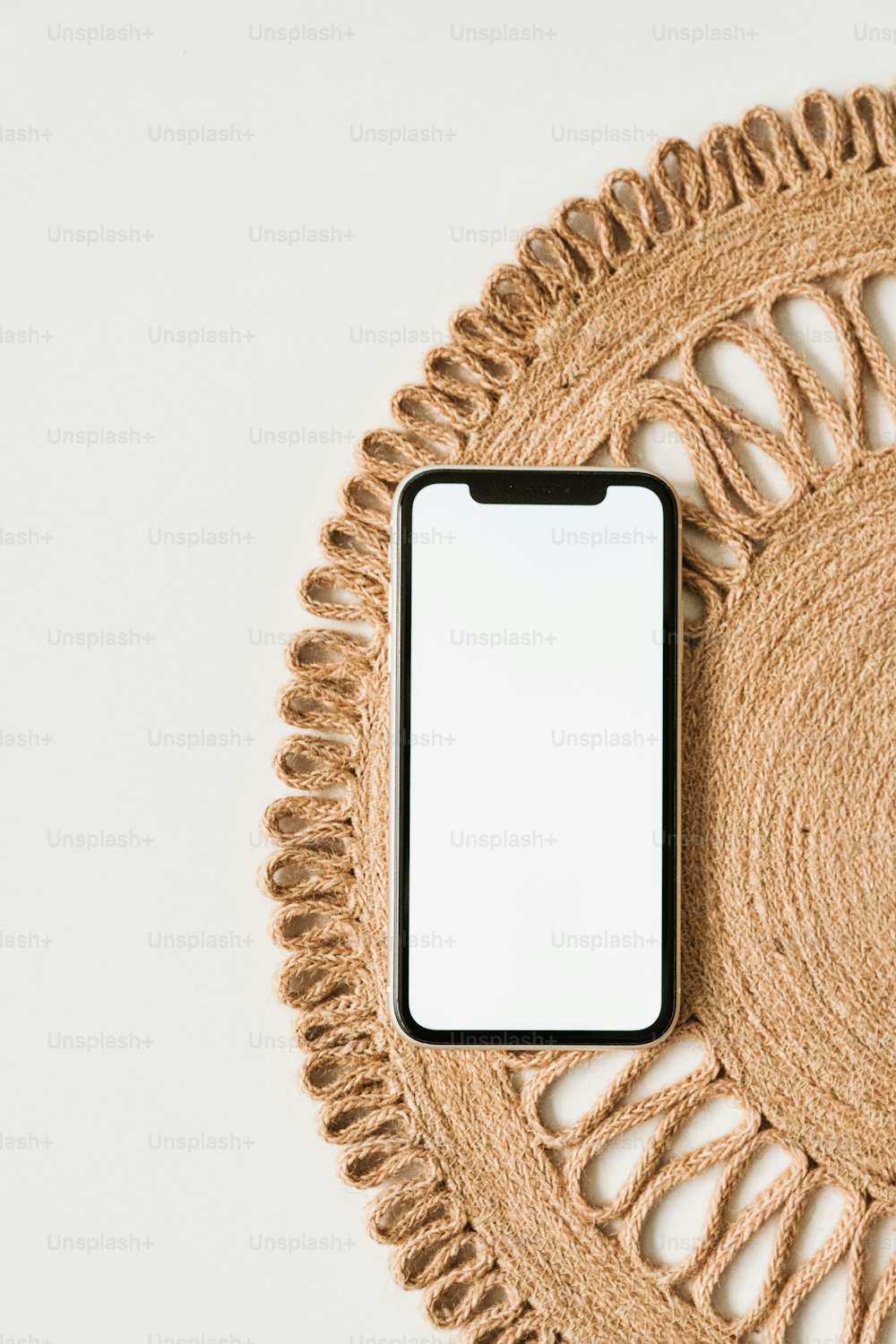 a cell phone sitting on top of a woven place mat