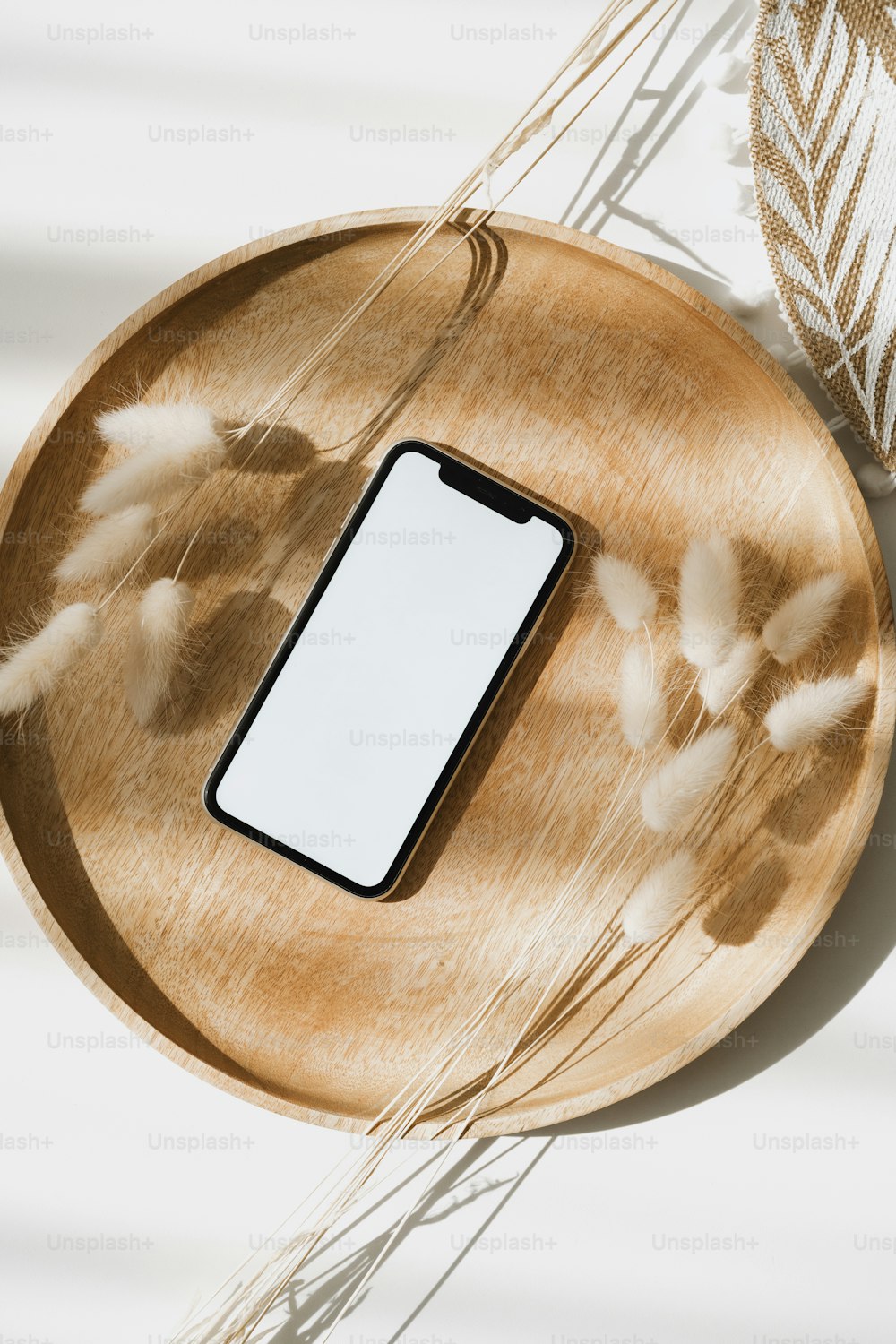 Un teléfono celular sentado encima de un plato de madera
