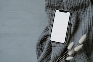 灰色の毛布の上に座っている携帯電話