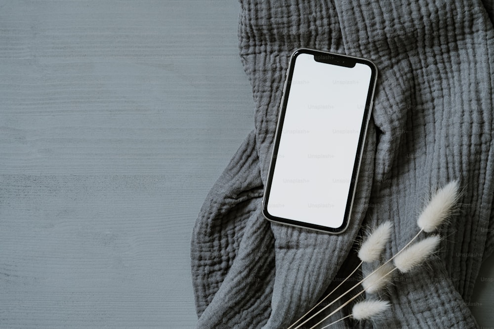 a cell phone sitting on top of a gray blanket