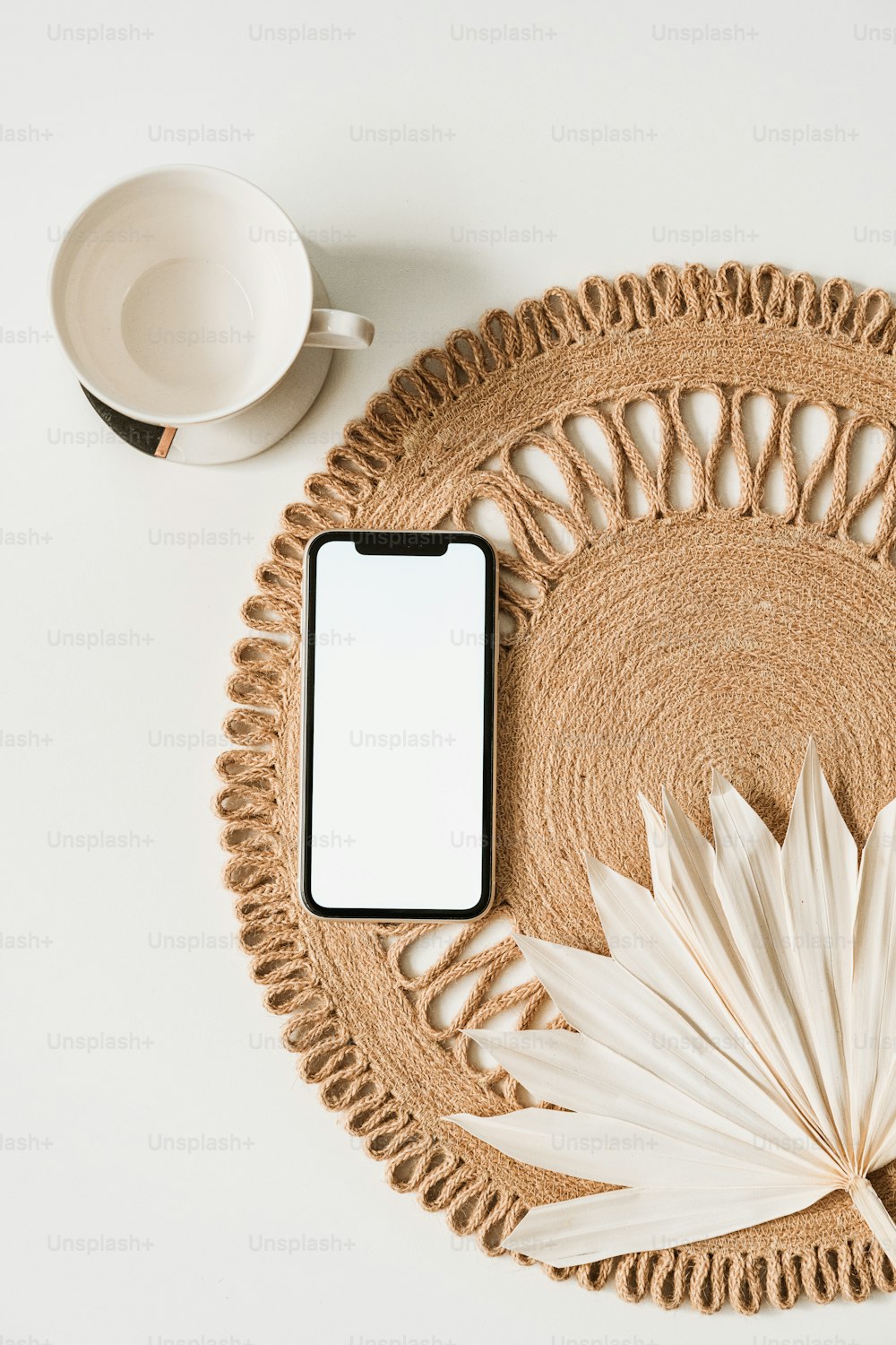 a cell phone sitting on top of a woven place mat