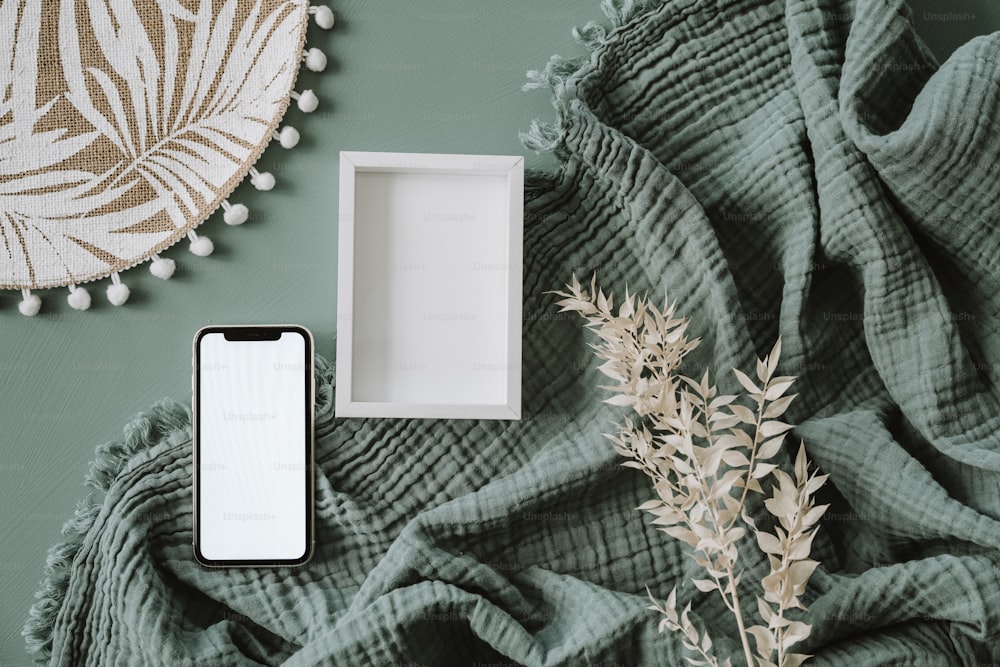 a white box sitting on top of a bed next to a plant