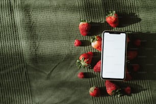 a cell phone sitting on top of a bed of strawberries