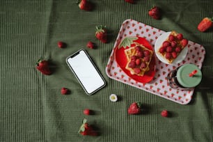 a table topped with a plate of food and a cell phone